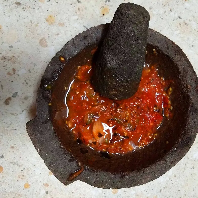 Salsa roja recién hecha en molcajete de piedra
